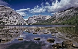 The storm clears over Tenaya Lake in Yosemite National Park, leaving peaks with snow covered trees.  Stepping stones tempt one to venture further towards the distant snow-covered shore.