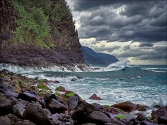 Storm approaches the Na Pali cliffs, waves thunder, and clouds swirl.  View from Keʻe Beach of Na Pali, north shore of Kauaʻi, Hawai'i.