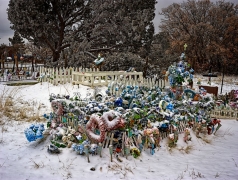 In a snowstorm on the high road to Taos, NM, we chanced on this grave of a child.  It is clear that the child is loved and missed from the profusion of ornamentation and care given the grave.