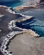 Besides extreme heat, geysers in Yellowstone National Park have high mineral content which evaporates leaving a white residue.  The edges struck me as being intricate as a doily with the colored algae making a true visual feast!